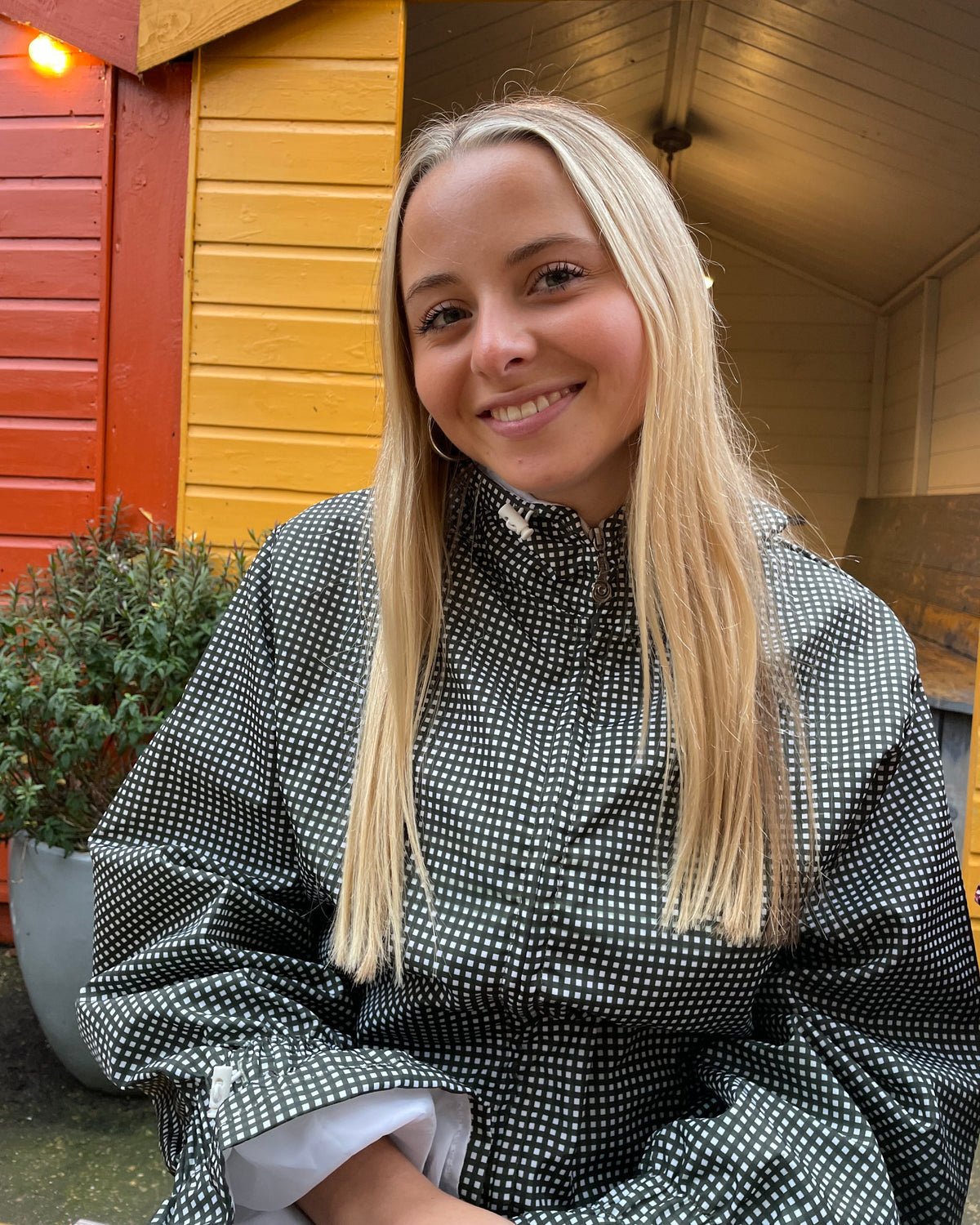woman wearing a olive gingham flared windbreaker