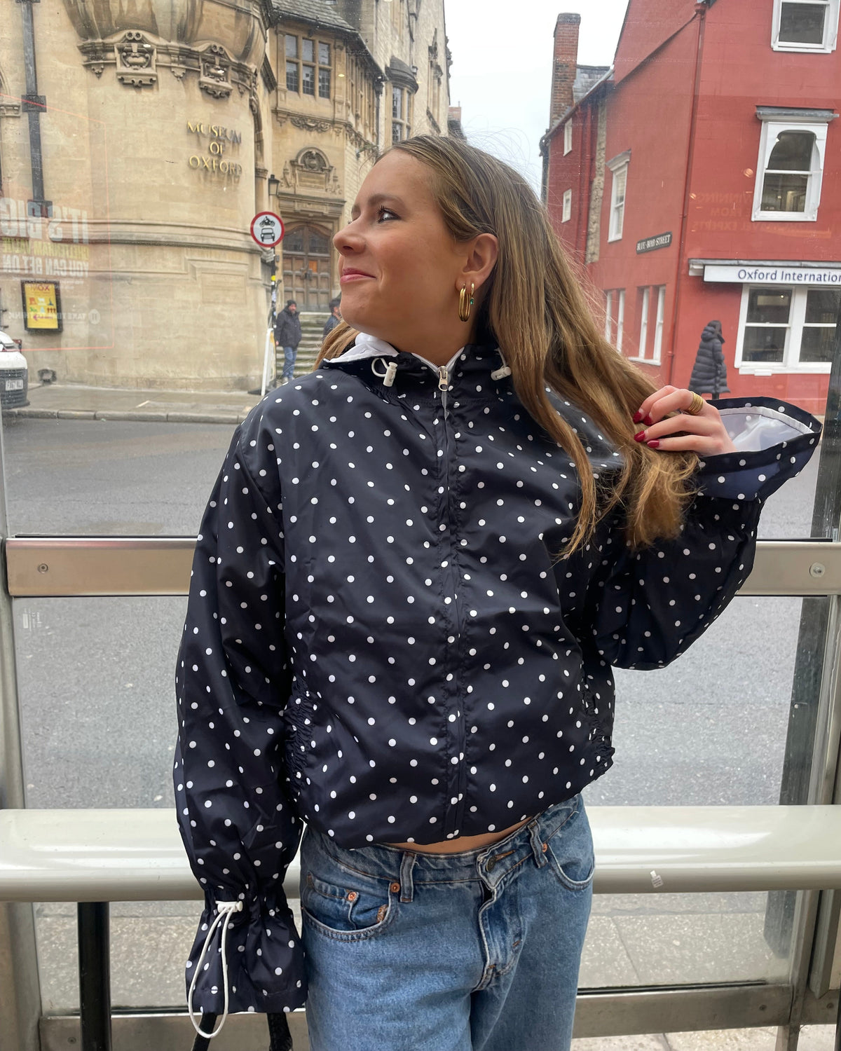 A woman wearing a flared polka dot windbreaker 