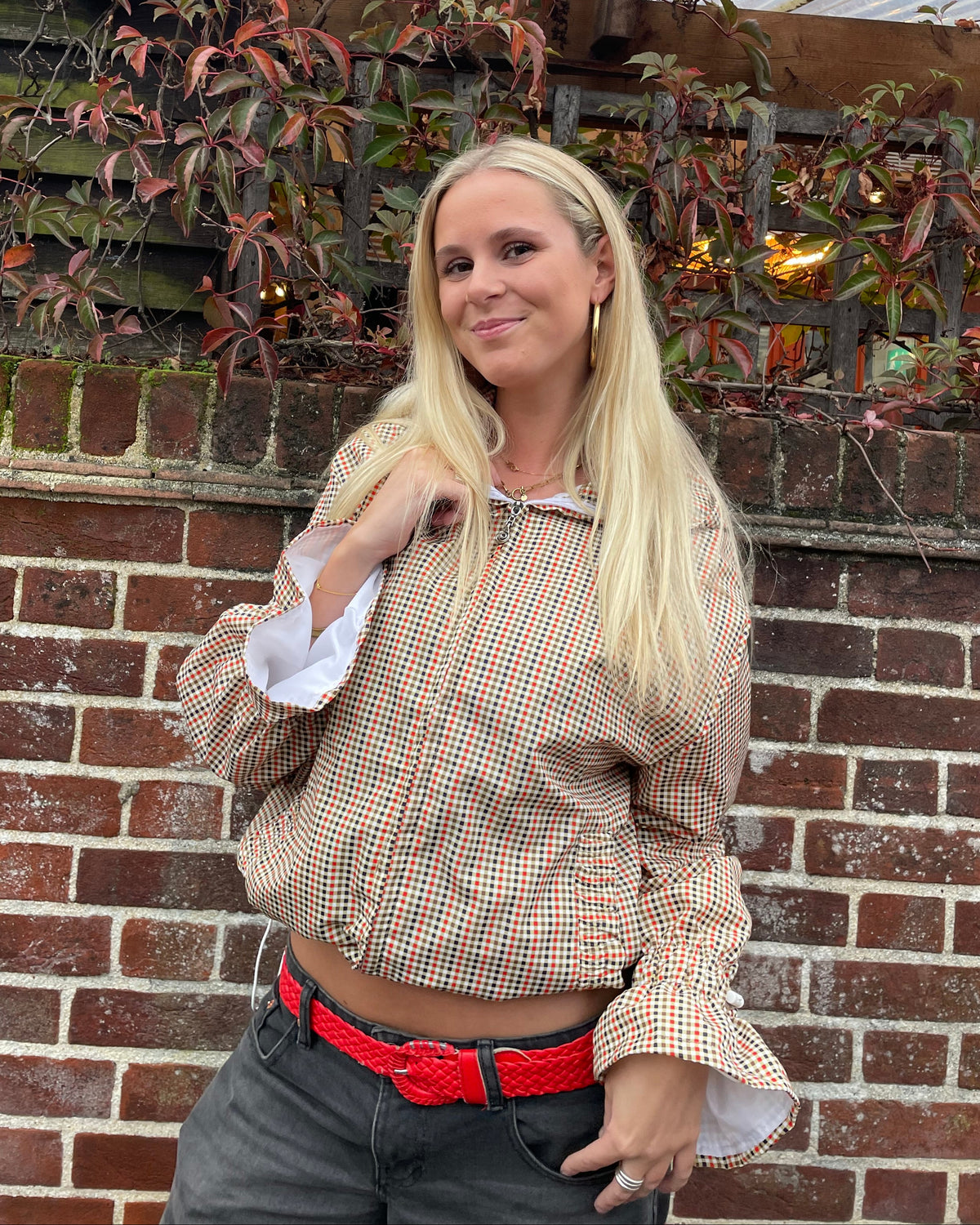a woman stood next to a wall wearing a maple flared windbreaker 