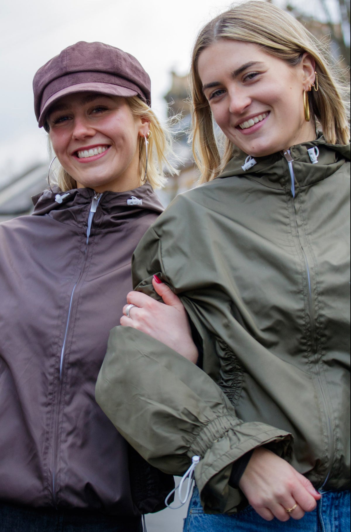 Two women wearing raincoats standing outdoors