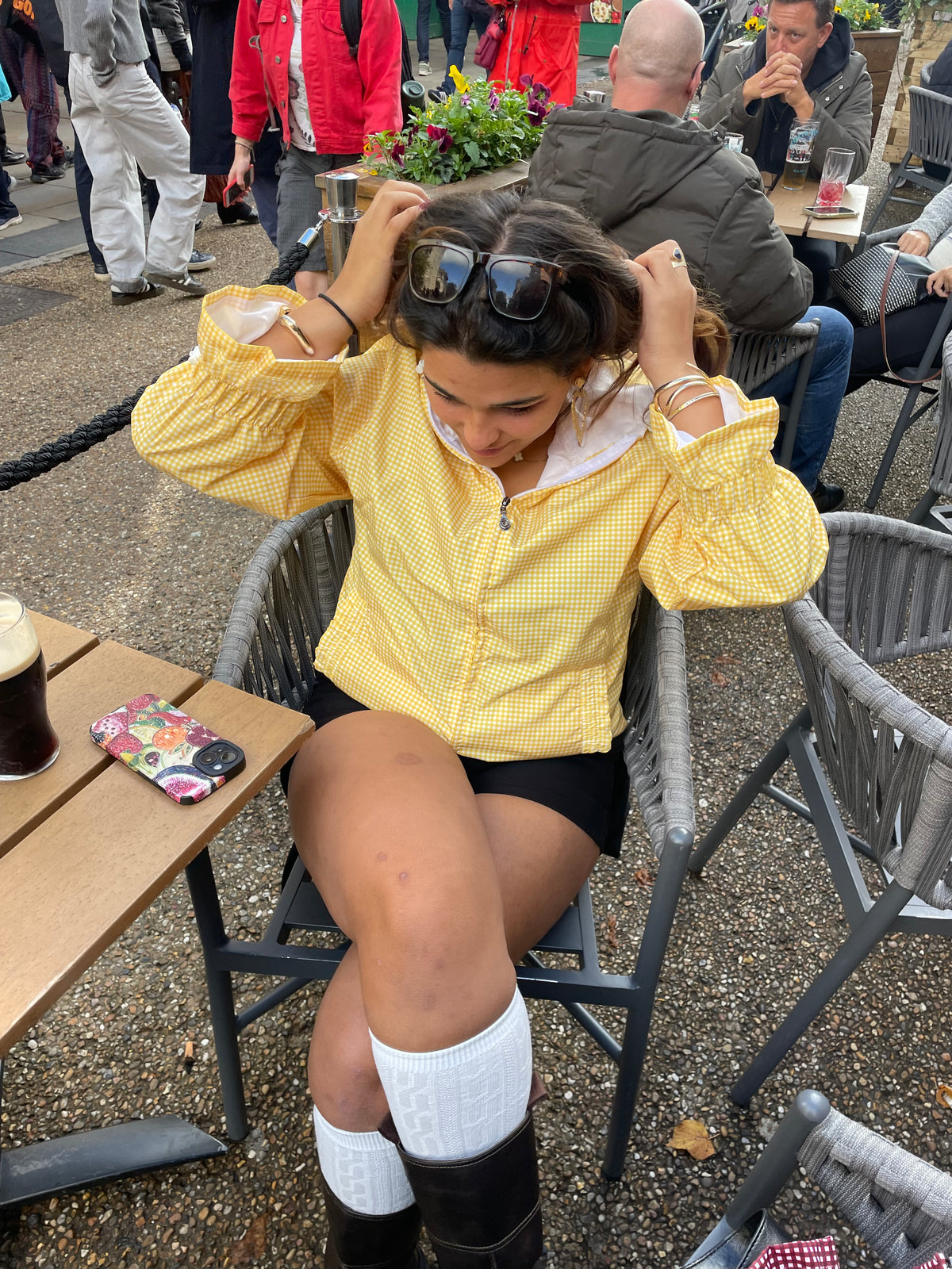 a woman outside a pub wearing a yellow windbreaker